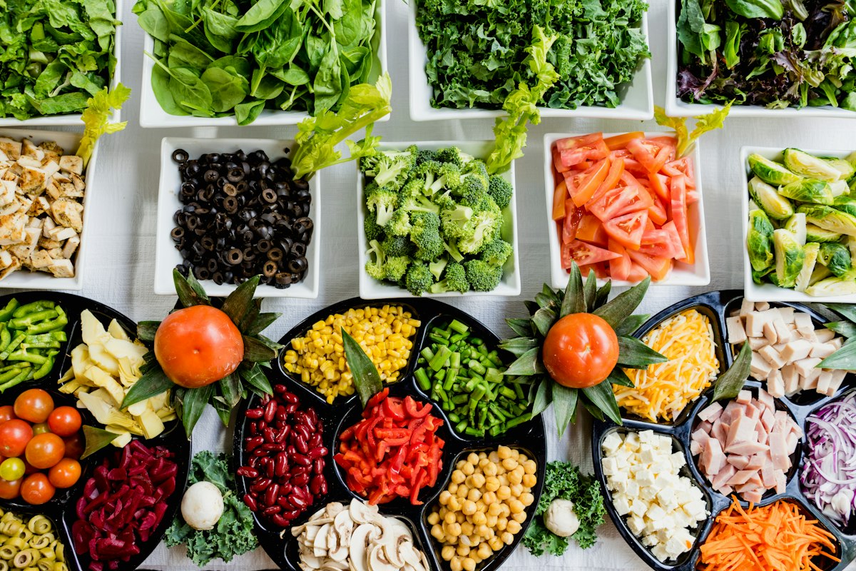 Plato colorido con verduras frescas, alcachofas y alimentos naturales que cuidan el hígado