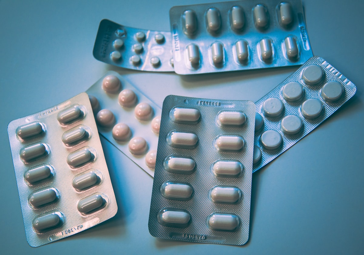 Suplementos y vitaminas sobre una superficie blanca